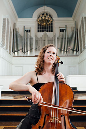 Eliza Meyer, cellist, in the Colby chapel with her instrument